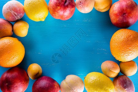 富有的蓝木桌上新鲜水果夏日静物丰收和健康食品的概念蓝木桌上的新鲜水果多汁油桃图片