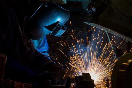 制造工人在厂焊接钢板部分技能蓝色的图片