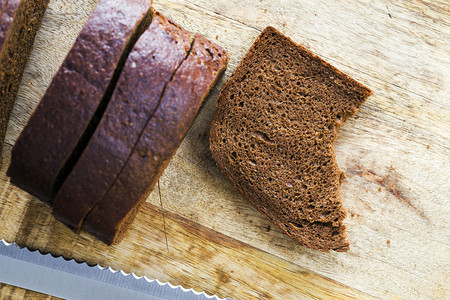 切片黑麦面包特写在桌子上一点被咬的黑麦面包切片饮食零早餐图片