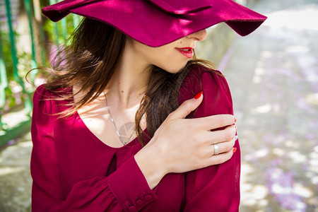 女士戴帽子的孩红色连衣裙双手特写戴帽子的女孩红色连衣裙感白色图片