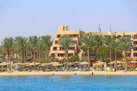 埃及的热带度假胜地人们在海中游泳客在海滩上放松人们在红海的滨度假胜地享受期在赫尔格达酒店休息埃及度假胜地游客在海滩上放松日光浴采图片