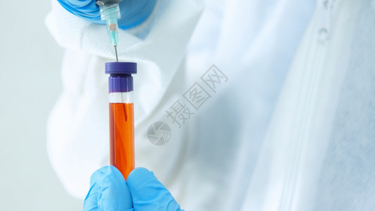 科学身穿生物防护服和蓝色手套的医生在试管中用白色背景上的注射器抽取血液样本的特写视图实验室混合图片