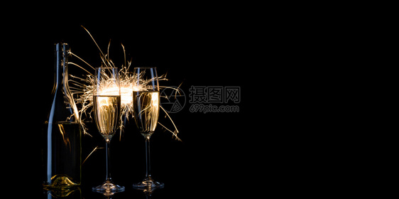 燃烧溅派对庆祝新年活动的概念和孟加拉灯光的两杯香槟酒和BanglanglightsBlackfric背景庆祝新年活动的概念图片