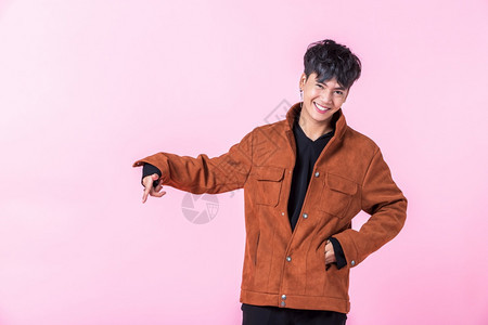 指点一个英俊的亚洲男子英俊的年轻男子用两手和指对着侧眼看在爱中孤立的相机在粉红色空白复制间室背景模型广告图片
