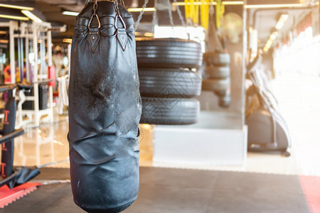 绞刑重的黑拳袋挂在抽象摘要中其模糊了运动设备为Gym模糊背景的体育锻炼设备操健身和俱乐部的分心拳击室内健身和俱乐部肌肉发达图片