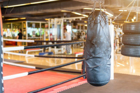 拳头黑袋挂在抽象摘要中其模糊了运动设备为Gym模糊背景的体育锻炼设备操健身和俱乐部的分心拳击室内健身和俱乐部斗争努力图片
