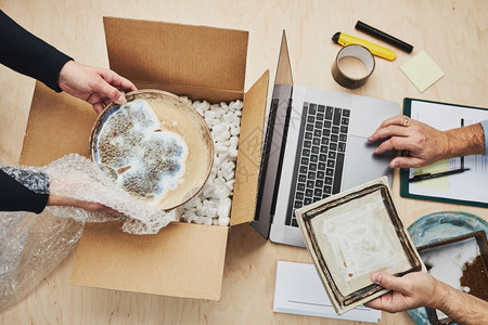 盒子企业主在线包装上订单向客户发货准备网上商店的装有陶瓷板制品的包裹盒航运销售图片