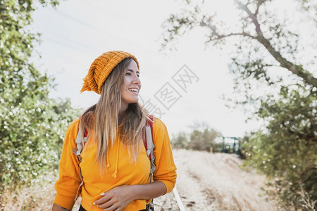 徒步旅行景观微笑的女人带着背包探索旧铁路轨迹享受周围的风景吧自由图片