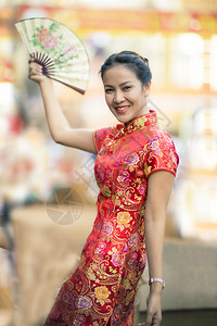 设计师扇子曼谷身着妇女传统服装的女在Yaowarat街Bangkokwea镇面露笑脸图片