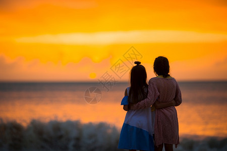 夏天美丽的快乐小女孩在日落的白沙滩上美丽的快乐小女孩在日落的白沙滩上行走俏皮晚图片