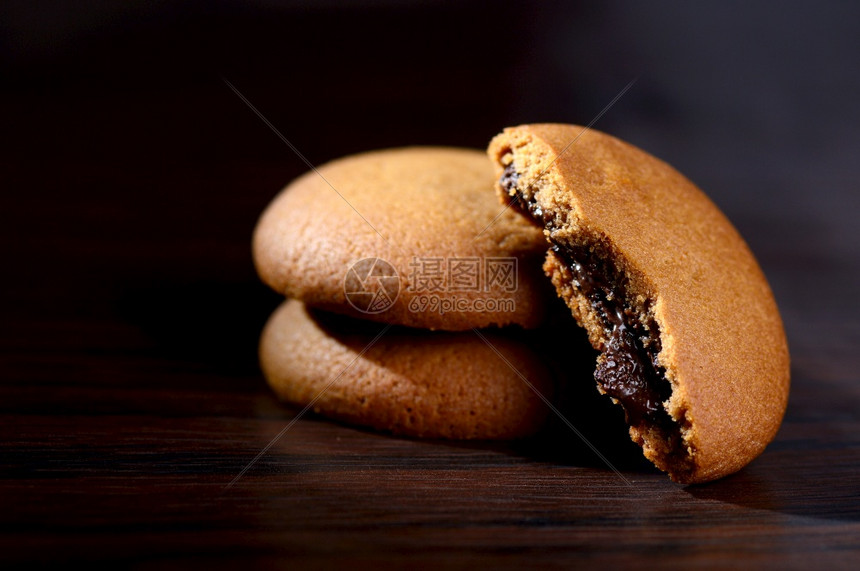 对待巧克力奶油饼干棕色巧克力黑色背景奶油馅面包店填充图片