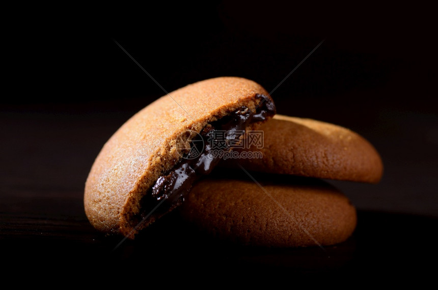 巧克力奶油饼干棕色巧克力黑色背景奶油馅诱人的小吃脆图片