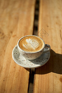 在木制桌上有选择焦点杯热拿铁艺术咖啡重点是白泡沫热拿铁木制咖啡可选择的豆子光滑图片