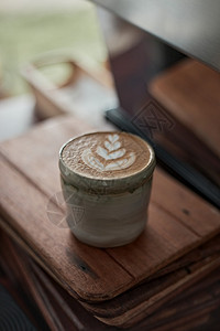 品尝黑暗的以白泡沫热拿铁艺术咖啡为焦点在木制桌上有选择地集中杯热拿铁艺术咖啡重点是白泡沫热拿铁艺术咖啡美食图片