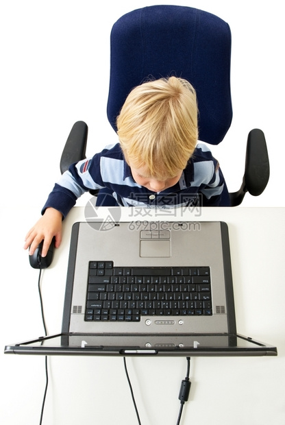 一个小男孩坐着使用笔记本电脑他的观点是俯视从胸部向上看他从胸前可以看到向左镜头浓度只要陷害图片