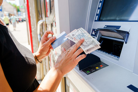 近距离接康辛女人的手在亚特姆接受支付帐单的钱在现金机银行用借记卡方自动售货机女图片
