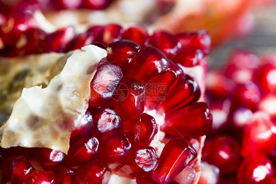素食主义者种子切红成熟石榴碎片和切紧闭含有大量铁质的多汁健康果子A切红成熟石榴多汁的图片