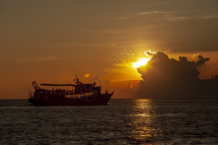 轮廓船漂浮的旅游潜水艇漂浮在泰国南部最受欢迎的游历达提奈顿港之一与美丽的日落天空相对抗图片