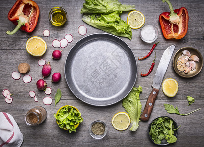 烹饪素食品成分的概念在锅盘周围铺放用刀子和香料空间作为生锈木背景顶底的文字版面铺设收成蔬菜图片
