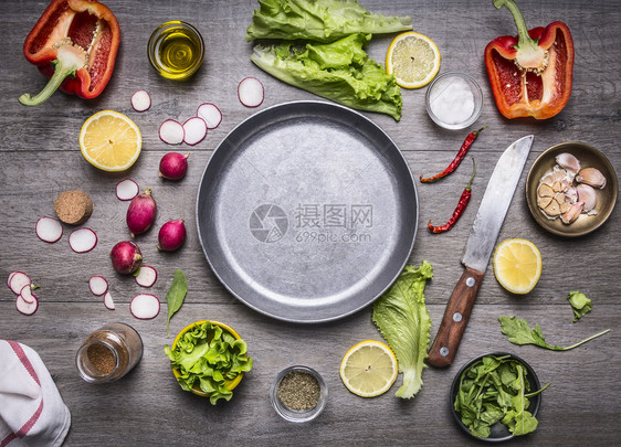 烹饪素食品成分的概念在锅盘周围铺放用刀子和香料空间作为生锈木背景顶底的文字版面铺设收成蔬菜图片