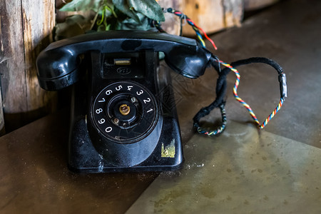 一张桌子上的旧黑电话时代的回转电信系统拨号子产品古董图片