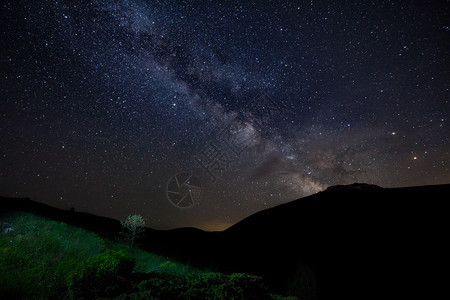 美丽的黄昏星空有银形的天和山岳绿草浅露的树丛非城市图片