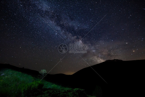 美丽的黄昏星空有银形的天和山岳绿草浅露的树丛非城市图片