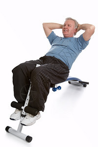 合身老的成熟人锻炼其腹部以保持体形健身房图片