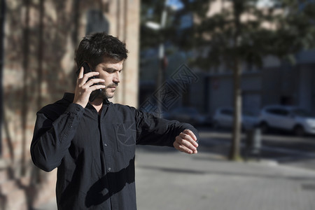 年轻人在街上行走时打通电话男士保持制造图片
