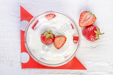 营养绿色和草莓酸奶在一木碗里用白本底勺子图片