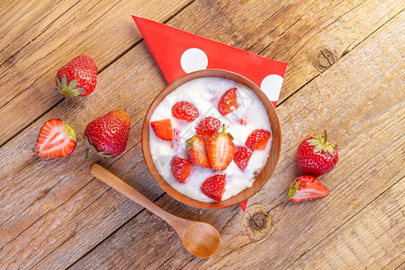 水果勺子有机的草莓酸奶和木本底碗中的草莓酸奶图片
