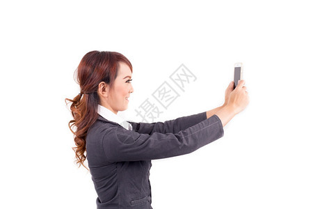 抓住肖像持有白色背景手机的年轻商业女青家人们图片