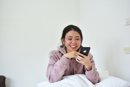 聪明的信息使用移动智能手机的妇女是离子卧室沟通图片