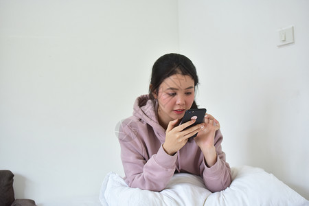 电话保持亚洲使用移动智能手机的妇女是离子卧室图片