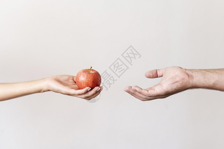 贫困分享年轻的用手给有需要人以苹果实图片
