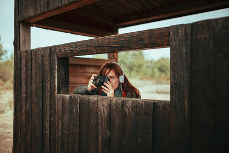 年轻女子在森林中木屋拍摄照片人们女士球衣图片