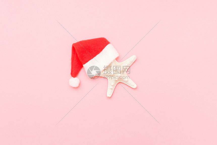 海星在粉红色背景的圣诞老人帽子与复制空间圣诞节或新年旅行创意概念顶视图平躺最小样式模板设计贺卡粉红色背景的圣诞老人帽子海星与复制图片