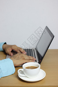 棕色木地板上的白咖啡杯和键盘上商人Hand的电脑笔记本并有复制空间输入你的工作想法个人电脑工作区桌面图片