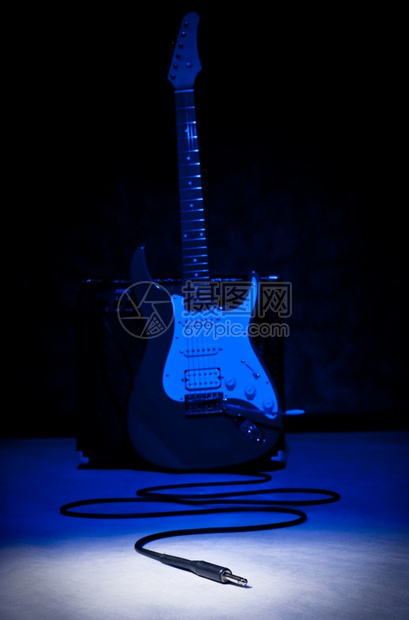 蓝色背景和聚光灯插上电吉他场景安培玩图片