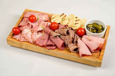 在白色背景的木板上不同种类的切碎香肠不同的在白色背景上使用不同类型的香肠熟食牛肉传统的图片