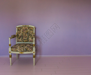 坐在一个有粉红色压层和紫石墙背景的空房间里中白色椅子结石古董屋图片