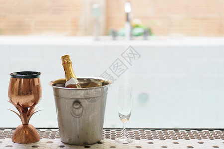 泳池边的冰桶香槟瓶背景图片