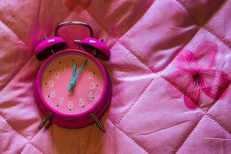 老的作品以粉红色毯子背景隔离的粉红旧时钟工作图片