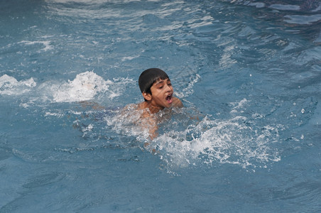 在泳池中游泳的小男孩图片