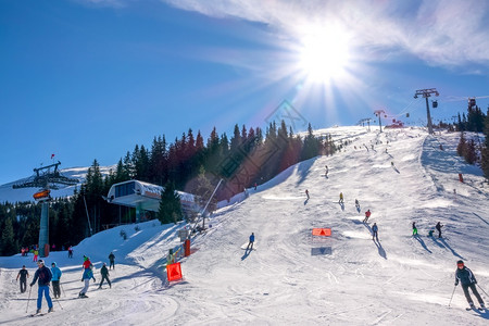 明亮的斯洛伐克冬季滑雪度假胜地JasnaBrightSun在蓝天的Jasna亮光日上在滑雪山坡升降机上面许多滑雪者在度假胜地和许图片