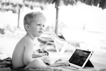 正面男孩婴儿坐在沙滩椅子上吃着饭在前面看石板半天的零食黑色和白的照片坐着涂抹图片