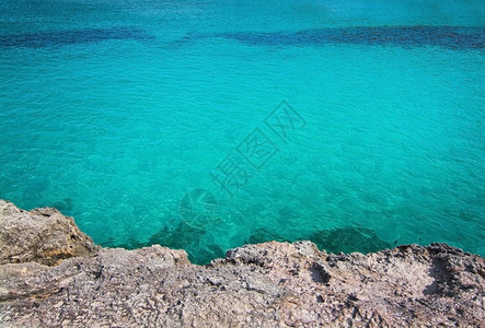 绿松石预订夏天西班牙巴利阿里群岛Mallorca的绿石岩和清澈水背景图片