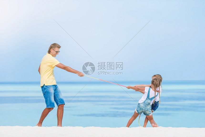 爸爸和孩子们在海滩上玩游戏图片