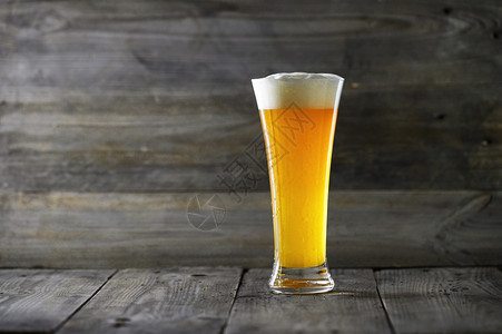 黑暗的带复制空间木质背景上玻璃啤酒带复制空间的木质背景上玻璃啤酒豪饮品脱图片