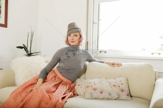 感的可爱坐在沙发上美丽女人时装术肖像放松图片
